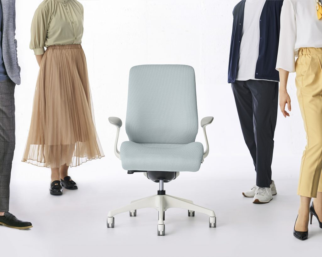 people standing around a gray chair